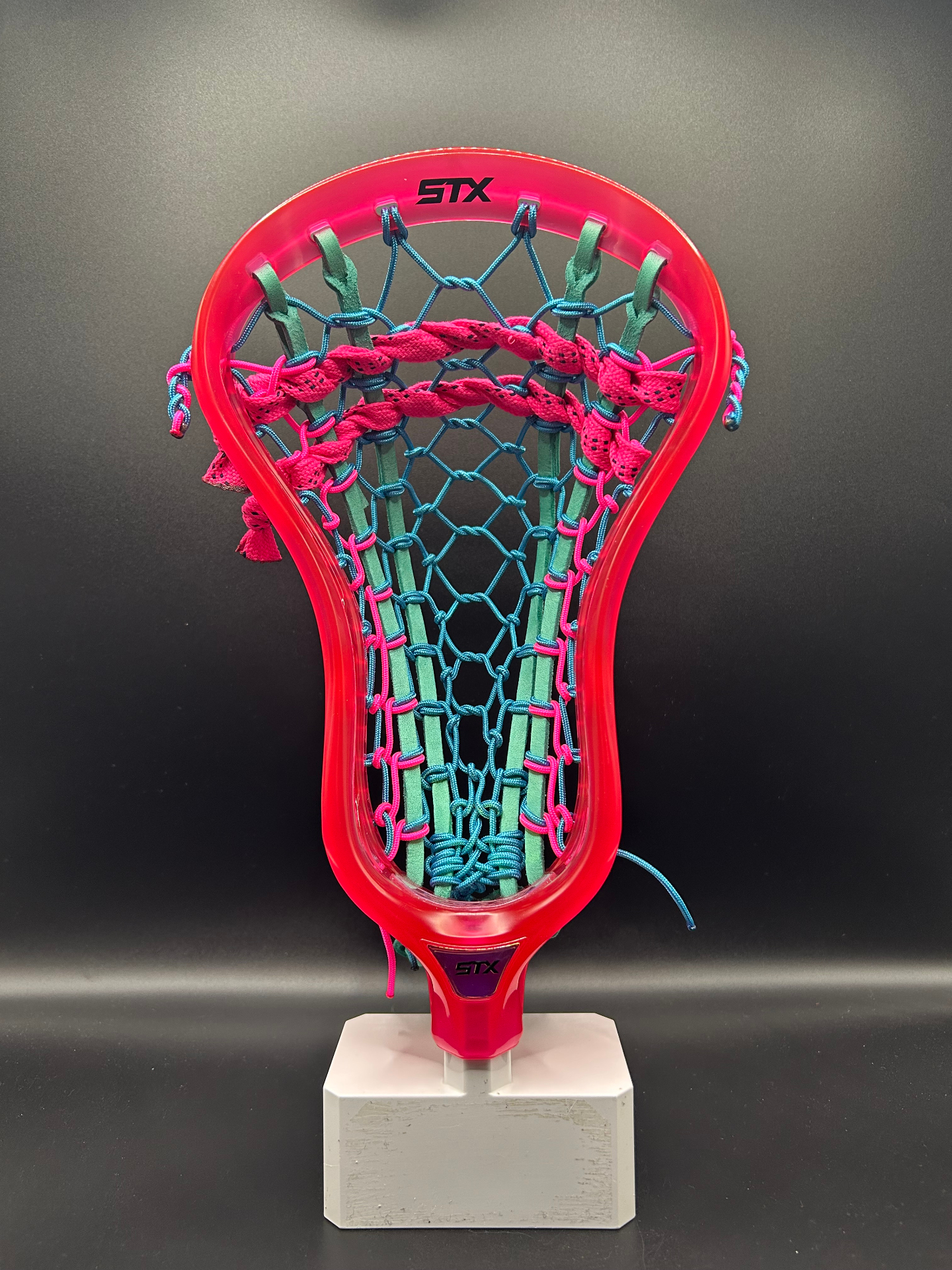 Custom pink and teal traditional lacrosse stringing on an STX head by Rev